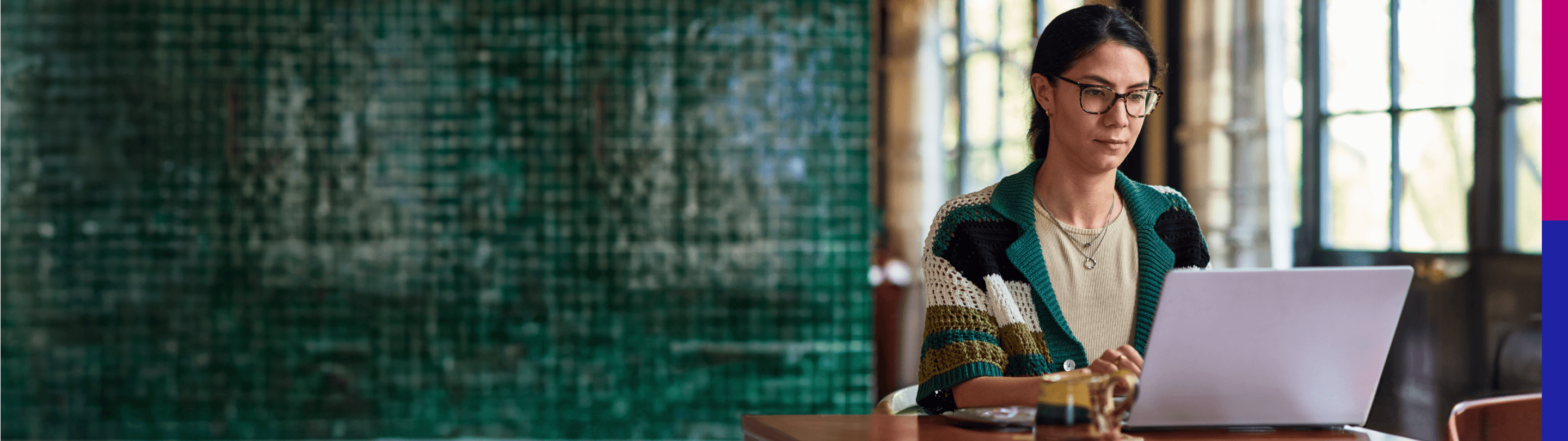 Photo of woman in glasses working on a laptop