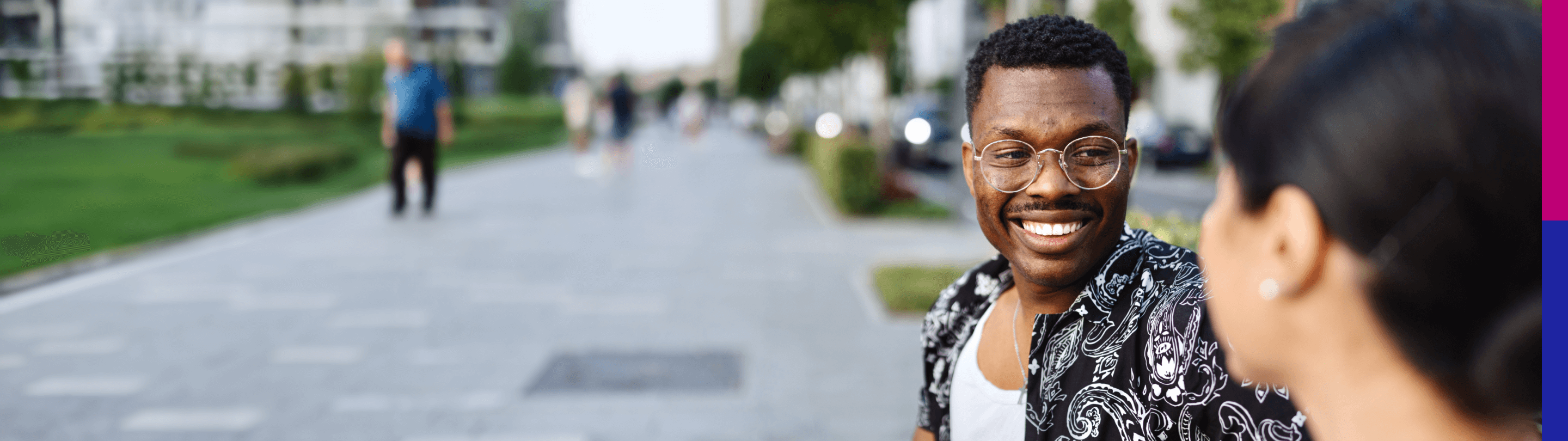 Man with glasses standing outside with a friend