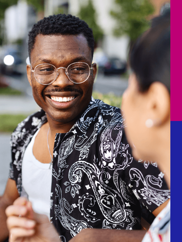 Man with glasses standing outside with a friend