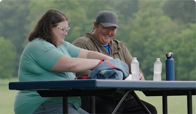 Avary and Ashleigh sit outside at a picnic table